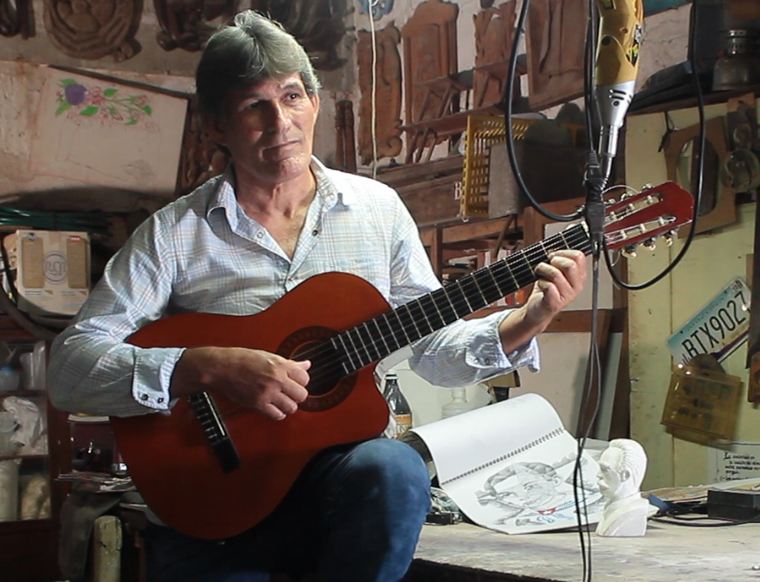 Mayito Duque tocando la guitarra en el taller